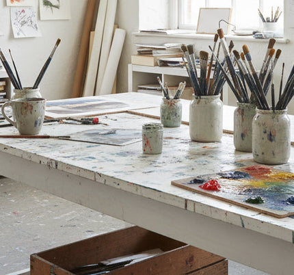 Contemporary abstract artist studio workspace with geometric paintings and meditation space