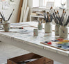 Contemporary abstract artist studio workspace with geometric paintings and meditation space