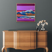 Artist Shilo Ratner, Mountain Valley, 30in x 30in, Wooden sideboard with decorative items against a dark wall with a colorful abstract painting.