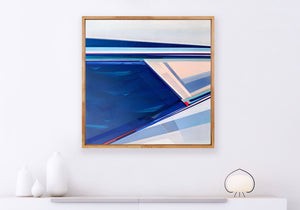 Geometric abstract painting in navy blue, blush, and white with diagonal lines, displayed in a natural wood float frame on a white wall by Shilo Ratner